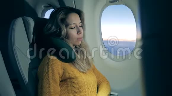 一个女人在飞机上睡觉时很放松视频的预览图