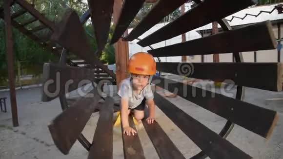 这个婴儿正在一个绳索镇玩耍这个男孩爬上孩子们设备一个孩子在操场上的桥上爬行视频的预览图