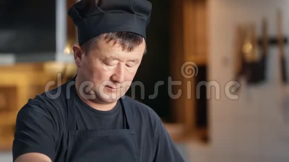 专注的韩国厨师在黑色统一混合食物准备炊具在厨房4k龙红相机视频的预览图
