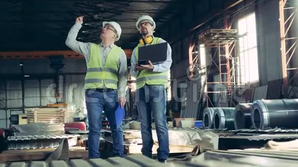 两名技术人员正在检查一个有屋顶材料的工厂视频的预览图
