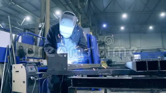 男性焊工在防护面罩是加工金属专业重工焊工在工厂工作视频的预览图