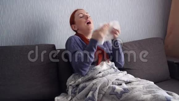生病的女人在家里打喷嚏成一条纸围巾视频的预览图