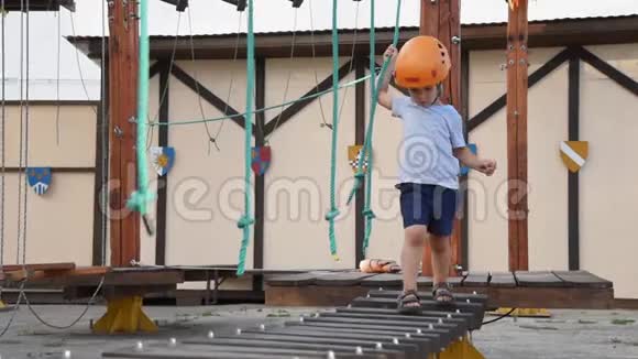 婴儿正在街上的一个绳镇玩耍一个男孩走在孩子们设备上一个孩子坐在摇摇晃晃的木桥上视频的预览图