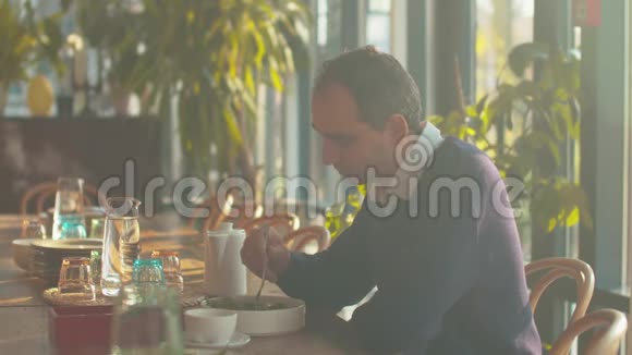 男人坐在咖啡馆的桌子旁吃沙拉视频的预览图