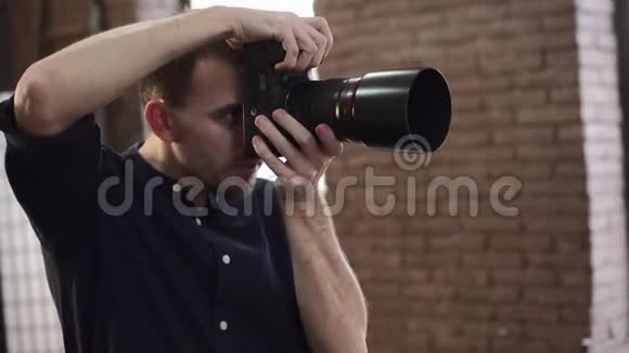 一位年轻的男性摄影师正在摄影棚里拍摄一个模特视频的预览图