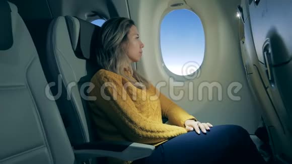 飞机舱和一个美丽的女人凝视着窗外视频的预览图