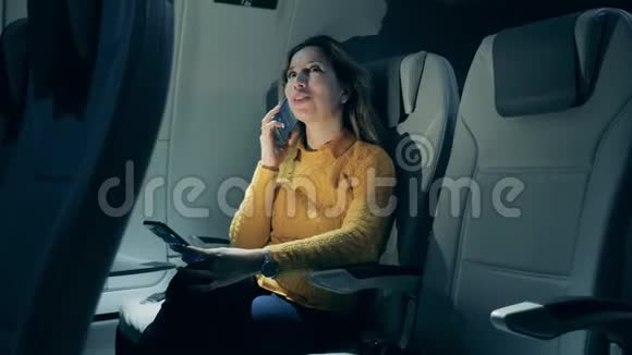一个女人坐在飞机舱里打电话视频的预览图