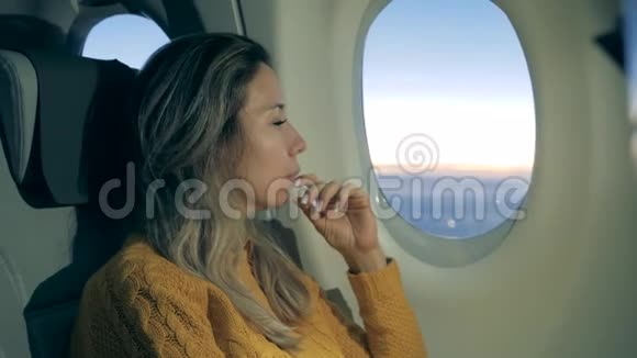 漂亮的女士正在看飞机的窗户在飞机上用笔记本电脑的女孩视频的预览图