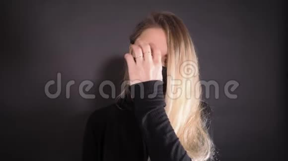 戴着黑色防护面罩的女人额头上写covid19的单词女孩从她的头发上推开一把视频的预览图