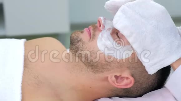 美容师用人造手套擦拭人脸保湿面膜视频的预览图