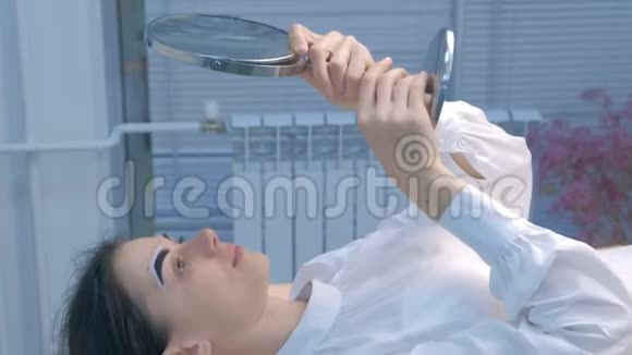 女人在美容过程中看镜子的帐篷眉毛侧视视频的预览图