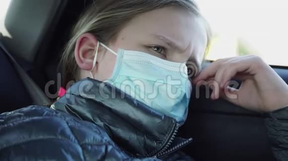 无聊的小女孩戴着口罩坐在汽车后座上检疫概念1视频的预览图