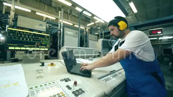男工程师在印刷厂操作笔记本电脑视频的预览图