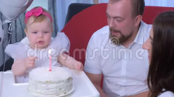 小女孩触摸蛋糕上的蜡烛在她的第一个生日时被烧掉并哭泣视频的预览图