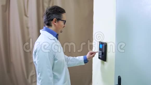 戴着实验室外套的勇人用手指按在指纹扫描机上进入门的安全系统视频的预览图