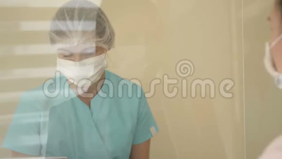 在医院候诊室值班护士正在与病人交谈护士和病人戴医用口罩病人视频的预览图