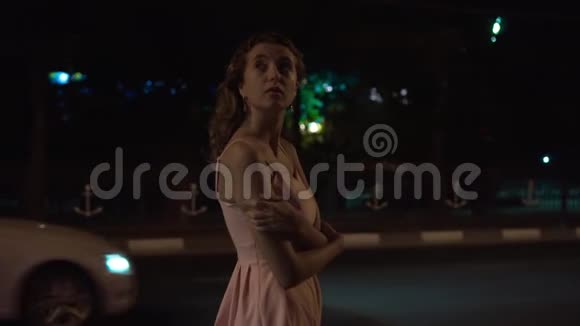 一个孤独的女孩晚上在城市里走来走去漩涡环顾四周视频的预览图