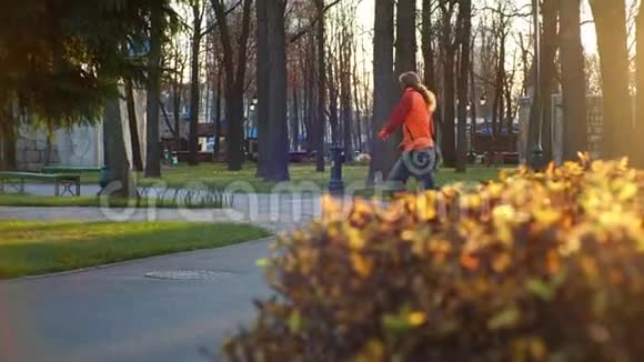 在一个城市的秋季公园里骑着滑旱冰的运动员表演职业技巧跳跃和转弯正常训练视频的预览图