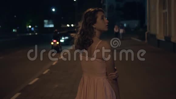 一个孤独的女孩在晚上绕着城市走旋转环顾四周视频的预览图