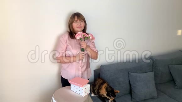 女人捧着一束粉红色的康乃馨花嗅嗅打喷嚏对植物花粉过敏视频的预览图