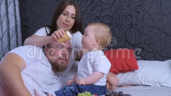 一家人的妈妈爸爸和小女孩在家一起吃葡萄和冰淇淋视频的预览图