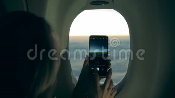 在飞机上拍照时女人手里一部手机视频的预览图