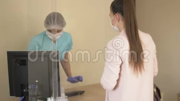 女性药剂师戴着医用口罩和手套在流行病期间为顾客服务药房的访客也在视频的预览图