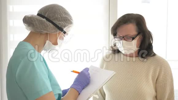 医生戴上口罩护目镜和一次性手套记录疑似病人的检查结果视频的预览图