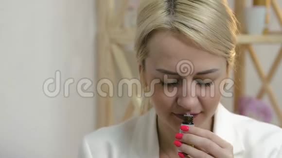 一位美丽迷人的女士在芳香疗法沙龙里嗅到一瓶精油这是一种美容和健康的概念视频的预览图