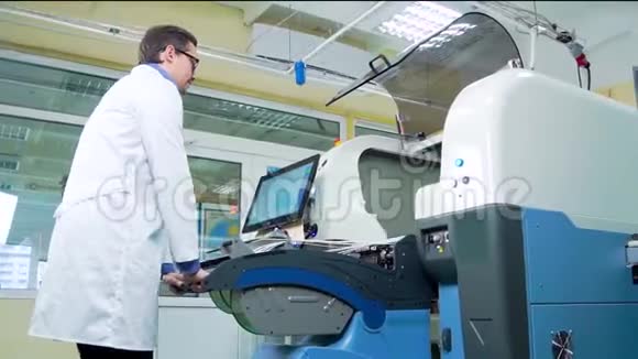 工程师穿着白色长袍和眼镜为表面安装技术机器工作数控机床PCB加工视频的预览图