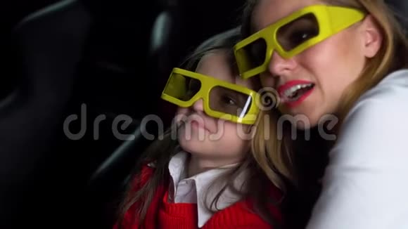 带着小女儿的女人带着3D眼镜看电影视频的预览图