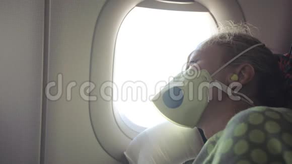 女人在飞机上旅行白种人戴着防护医疗面罩带呼吸器的飞机上的女游客感觉不好视频的预览图