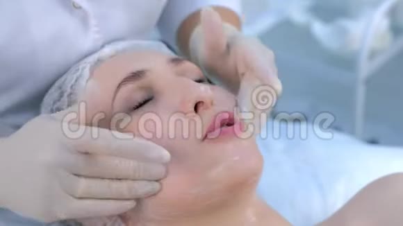 美容师正在用保湿霜对女性面部进行面部按摩视频的预览图