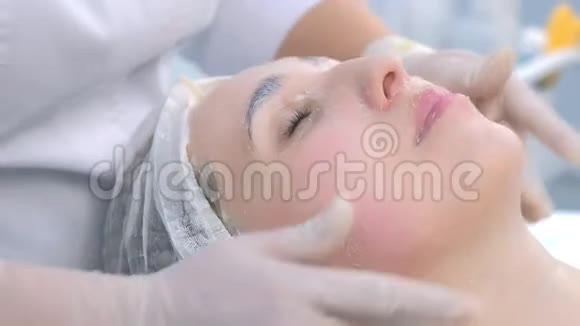 美容师在女人脸上用去皮面膜做面部按摩特写视频的预览图
