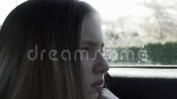 悲伤的女孩在车里无聊从车窗外看视频的预览图