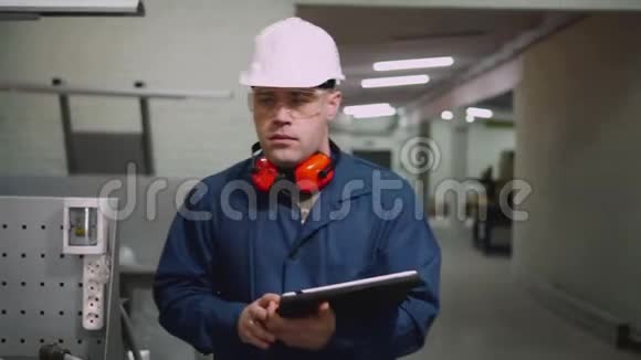一名男性工厂工人正在使用平板电脑在车间上行走视频的预览图