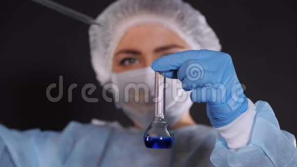 一滴蓝色液体从一个玻璃管中落入一个透明落入透明容器视频的预览图