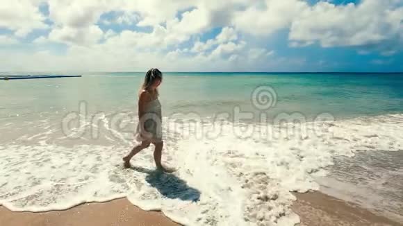 无人照顾的女士正在低潮时沿着海岸散步视频的预览图