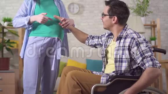 一个坐轮椅的残疾人和他怀孕的妻子未来的父母视频的预览图