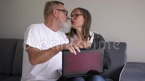 快乐的中年夫妇笑着说一起用笔记本电脑看电脑屏幕视频的预览图