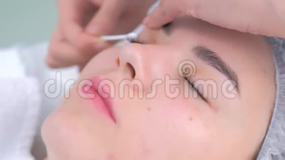 美容师擦拭眼睛棉棒后睫毛分层提升程序视频的预览图
