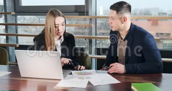 男人和女人在灯火通明的现代办公室里讨论工作从事手提电脑工作的有关男女视频的预览图