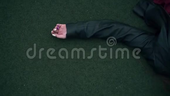 一个美丽而热情的女孩躺在法庭的地板上一个年轻的女人躺在球场的绿色表面上视频的预览图