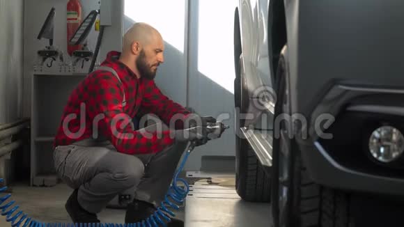汽车修理厂的专业技工在客车上更换车轮视频的预览图