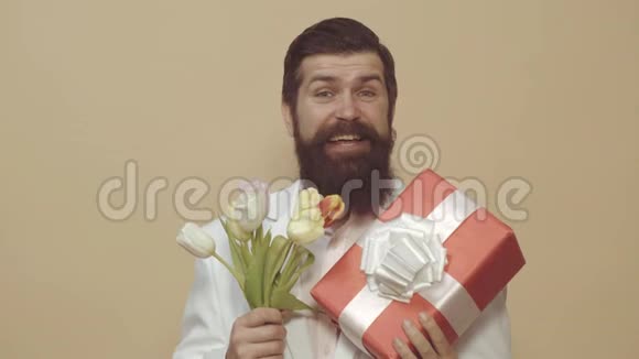 留胡子的人拿着一束鲜花和礼品盒情人节女人日生日视频的预览图