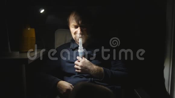 一个年轻的白种人晚上吸入肺部台灯闪亮椅子上的人在呼吸视频的预览图