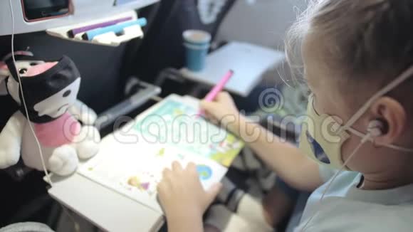 小女孩白种人在飞机上戴着防护面罩带呼吸器的飞机上的儿童婴儿游客视频的预览图