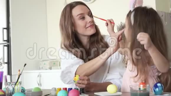 可爱的女儿和妈妈一起准备复活节互相玩耍视频的预览图
