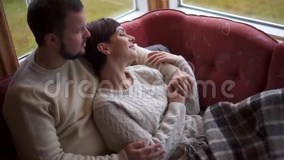 浪漫的夫妇躺在家里的沙发上视频的预览图