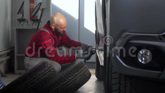 汽车修理厂的专业技工在客车上更换车轮视频的预览图